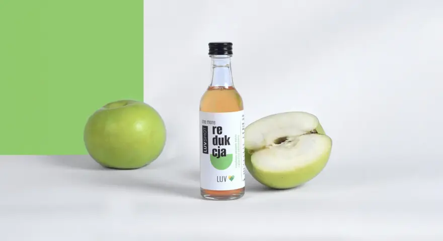Butelka z napojem i jabłka. Produkt LUVSHOT, który podkreśla ocet jabłkowy właściwości.