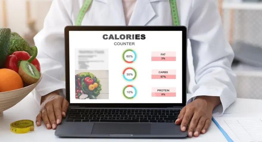 Dieta kopenhaska dokładny jadłospis. Na ekranie laptopa licznik kalorii z podziałem na tłuszcze, węglowodany i białka.