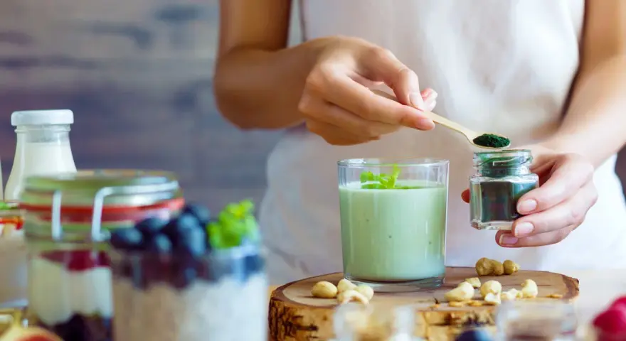 Dodawanie spiruliny do smoothie to jeden ze sposobów, jak obniżyć CRP naturalnie. Zdrowy koktajl z owocami i orzechami.